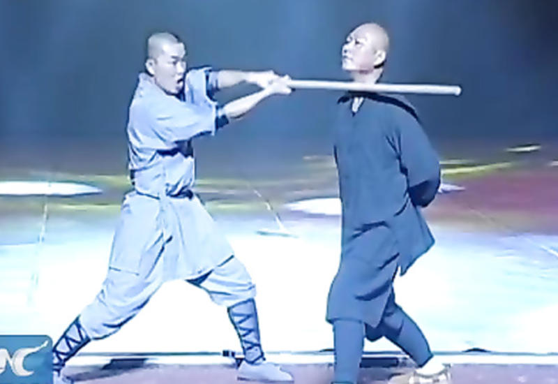 Монах Шаолиня ломает палки шеей