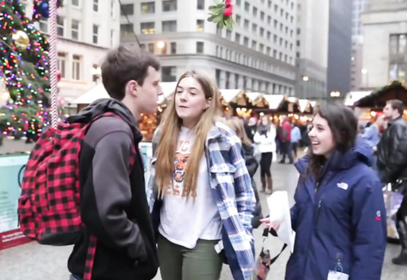 Девушки целуют парня прямо на улице