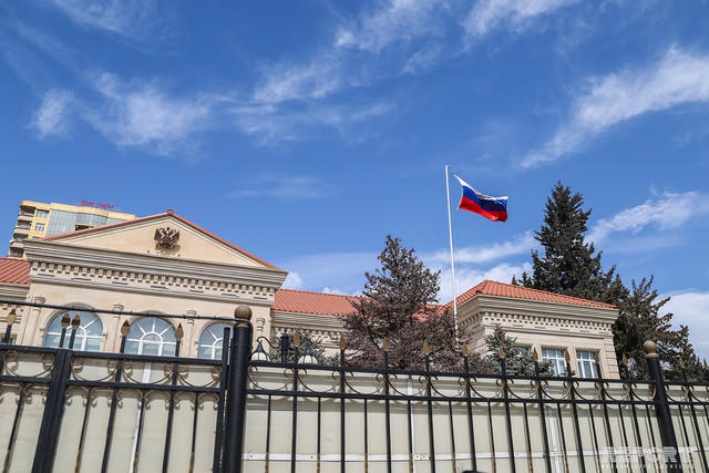 Жители Баку несут цветы к посольству России