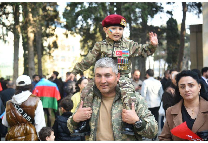 На площадь Азадлыг собираются люди, чтобы наблюдать за военным парадом